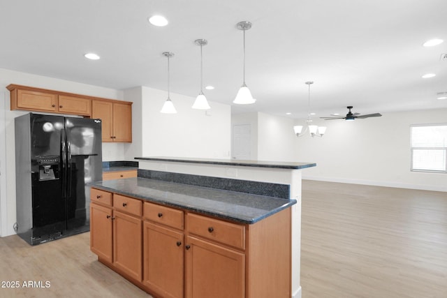 kitchen with recessed lighting, black fridge with ice dispenser, light wood finished floors, and a kitchen island