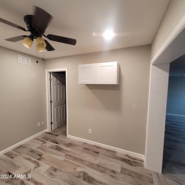 unfurnished room with light wood-type flooring and ceiling fan