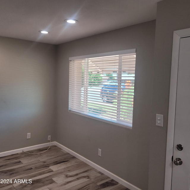 empty room featuring a healthy amount of sunlight and hardwood / wood-style floors