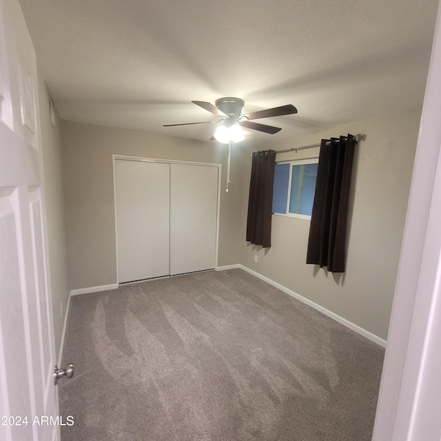 unfurnished bedroom with ceiling fan, carpet, and a closet