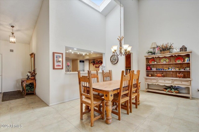 dining room with high vaulted ceiling, a skylight, and a chandelier