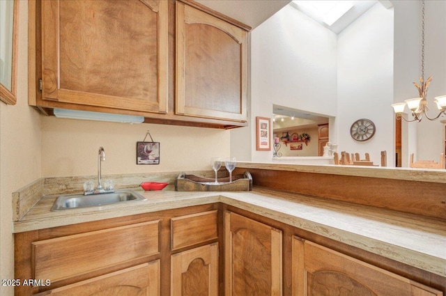 kitchen with a notable chandelier, a skylight, and sink