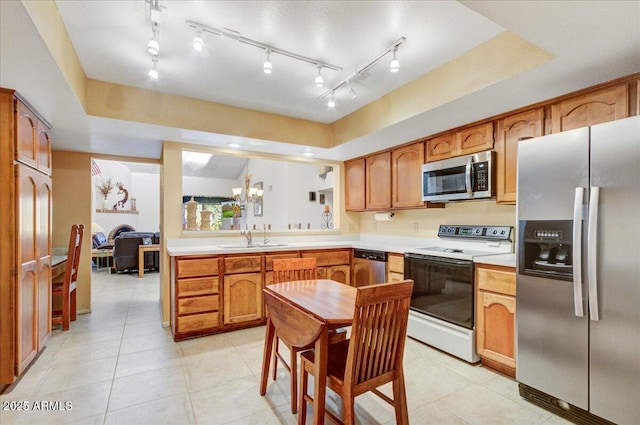 kitchen with a notable chandelier, light tile patterned floors, stainless steel appliances, and sink