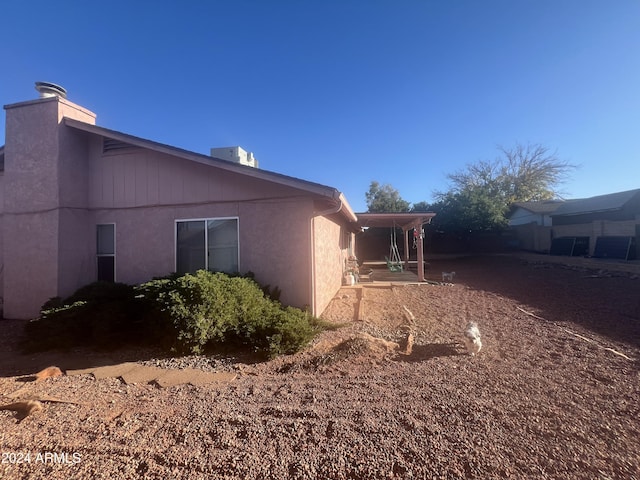 view of side of property with central air condition unit and a patio