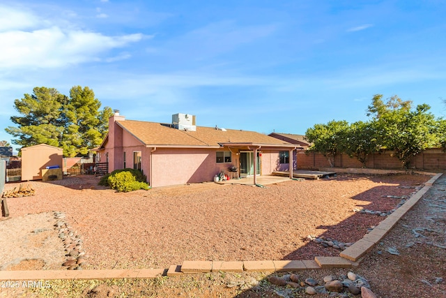 back of property with a storage shed