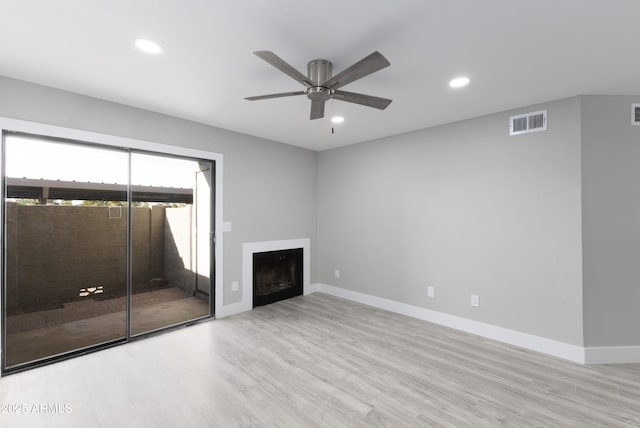 unfurnished living room featuring visible vents, baseboards, recessed lighting, a fireplace, and wood finished floors