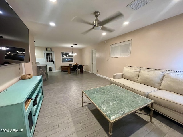 living room featuring ceiling fan with notable chandelier