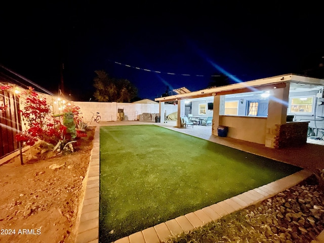 yard at twilight featuring a patio