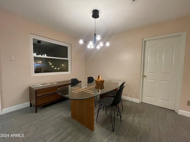 dining space with dark hardwood / wood-style floors and a chandelier