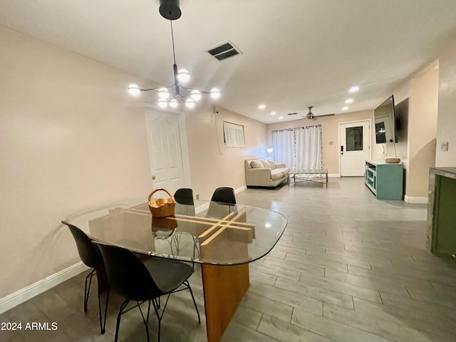 dining area featuring ceiling fan with notable chandelier