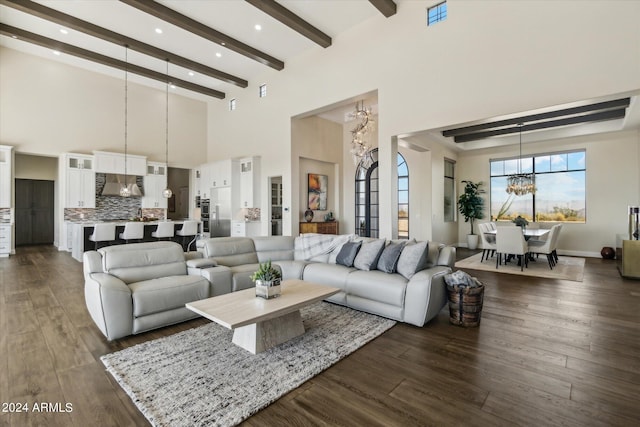 living room with beamed ceiling, dark wood-type flooring, a chandelier, and a towering ceiling