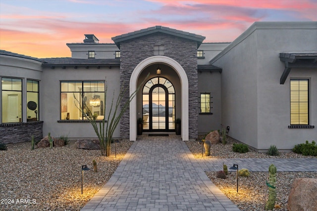 exterior entry at dusk featuring french doors