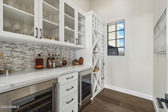 bar with white cabinetry, wine cooler, and light stone counters