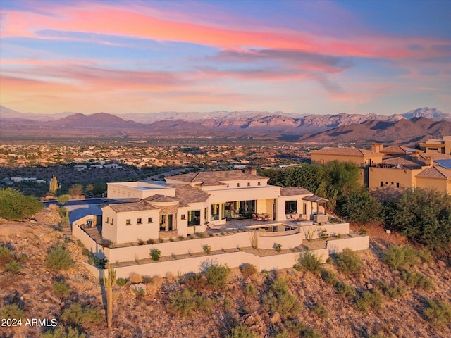 aerial view at dusk featuring a mountain view