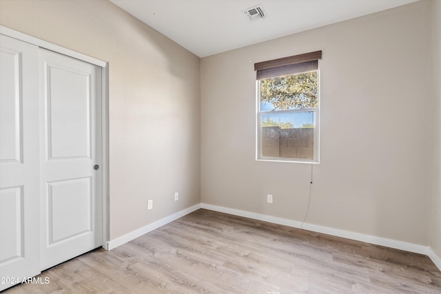 unfurnished bedroom with light hardwood / wood-style floors and a closet