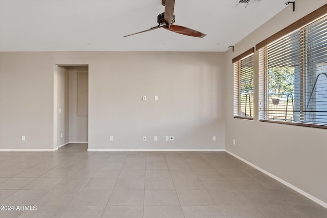 empty room with ceiling fan and light tile patterned floors