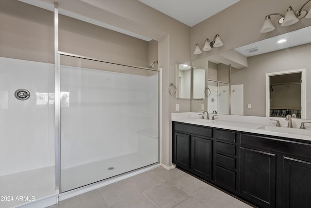 bathroom with tile patterned flooring, vanity, and a shower with shower door