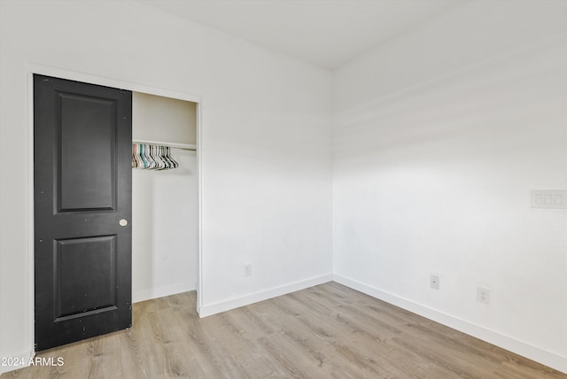 unfurnished bedroom with a closet and light hardwood / wood-style floors