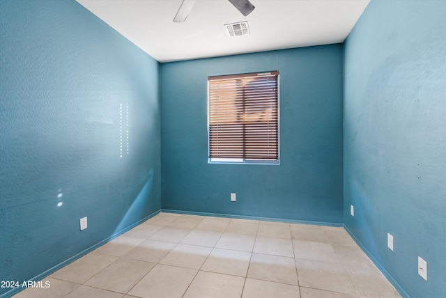 tiled empty room featuring ceiling fan