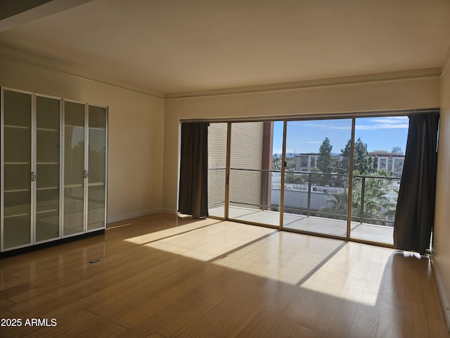 unfurnished room with crown molding and hardwood / wood-style floors