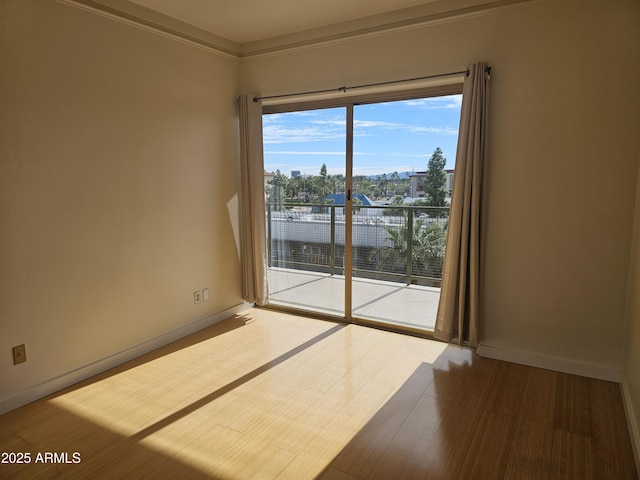 spare room with hardwood / wood-style flooring and crown molding