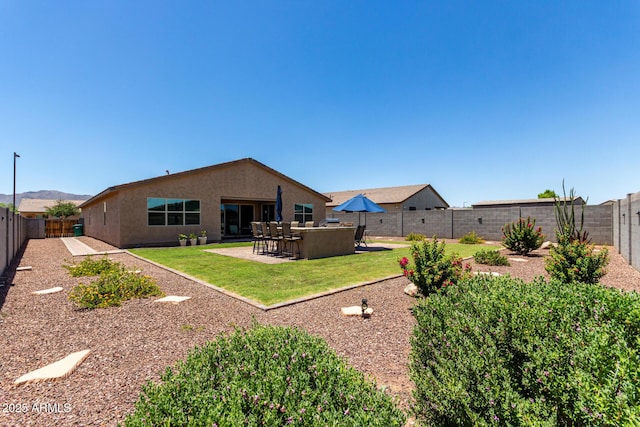 8741 N 185th Ave, Waddell, AZ 85355 - rear view of house with a fenced backyard, a patio, and stucco siding