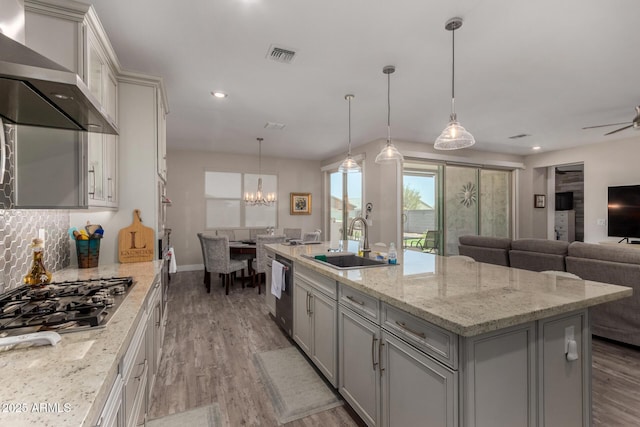 8741 N 185th Ave, Waddell, AZ 85355 - kitchen with wall chimney range hood, appliances with stainless steel finishes, gray cabinets, open floor plan, and a chandelier