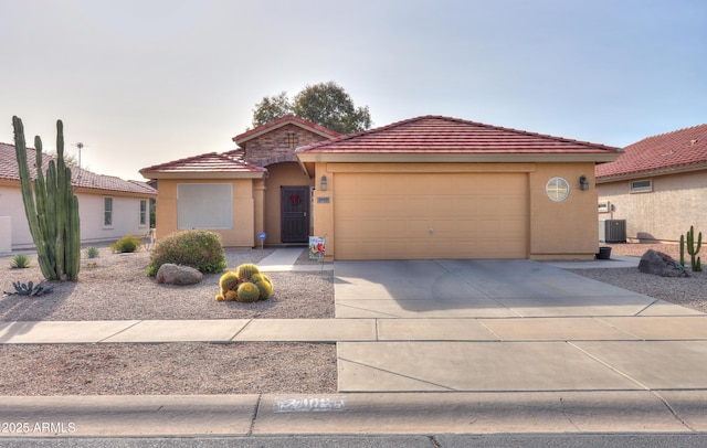 mediterranean / spanish home featuring central AC unit and a garage