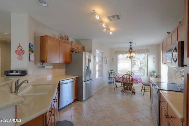 kitchen featuring pendant lighting, sink, light tile patterned floors, and appliances with stainless steel finishes