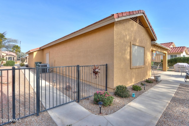 view of property exterior with central AC unit and a patio area