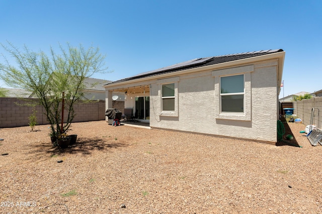 18711 W Farmer Rd, Buckeye, AZ 85326 - back of house featuring roof mounted solar panels, a fenced backyard, stucco siding, and a patio area
