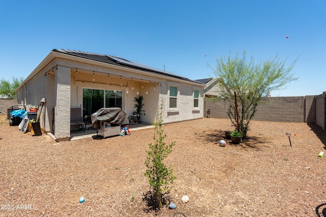 18711 W Farmer Rd, Buckeye, AZ 85326 - rear view of property with solar panels, a fenced backyard, and stucco siding