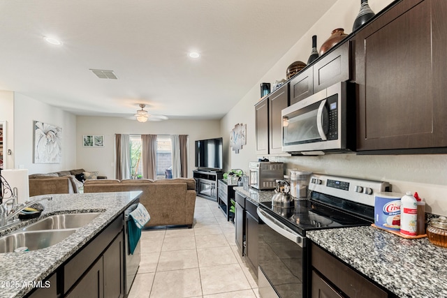 18711 W Farmer Rd, Buckeye, AZ 85326 - kitchen featuring stainless steel appliances, a sink, dark brown cabinets, open floor plan, and recessed lighting