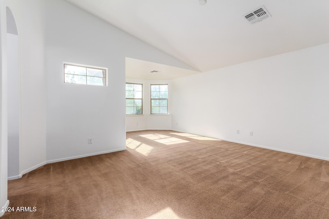 unfurnished room with carpet floors and high vaulted ceiling