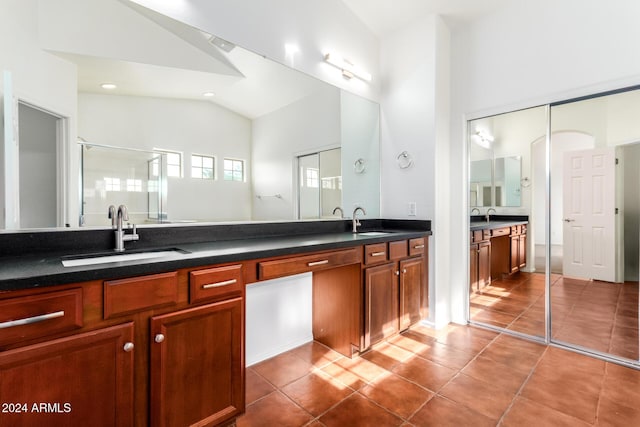 bathroom with tile patterned flooring, vanity, a shower with door, and vaulted ceiling