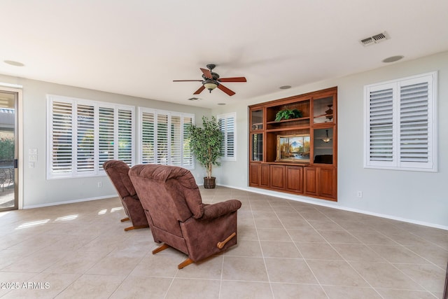 tiled living room with ceiling fan