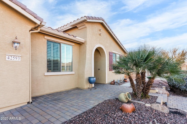 view of exterior entry with a patio