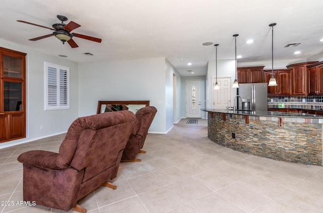 living room featuring light tile patterned floors, ceiling fan, and sink