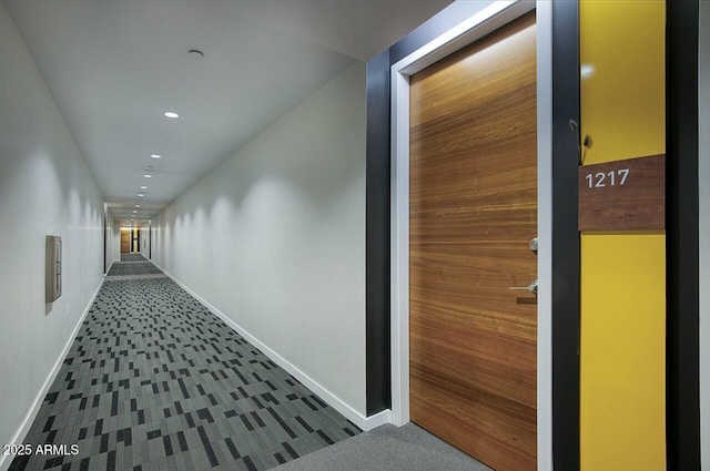 corridor with baseboards, dark colored carpet, and recessed lighting