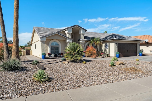 view of front of home with a garage, stucco siding, concrete driveway, and a tiled roof