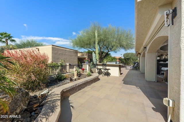 view of patio / terrace with fence and outdoor dry bar