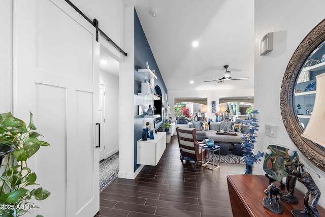 interior space featuring a barn door, ceiling fan, wood tiled floor, high vaulted ceiling, and recessed lighting