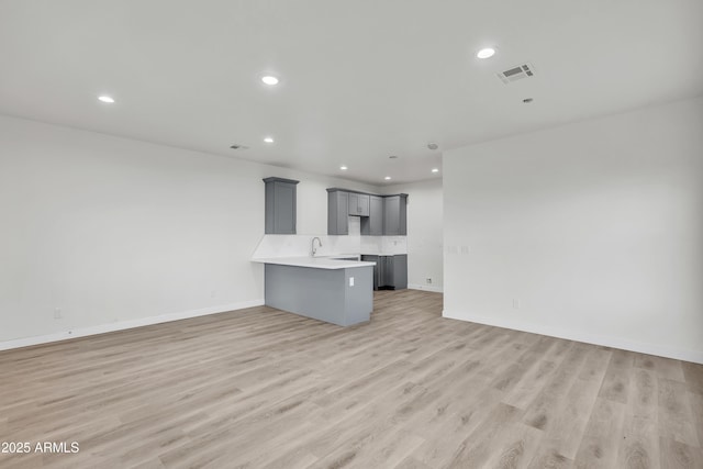 kitchen with light wood-style flooring, open floor plan, and gray cabinetry