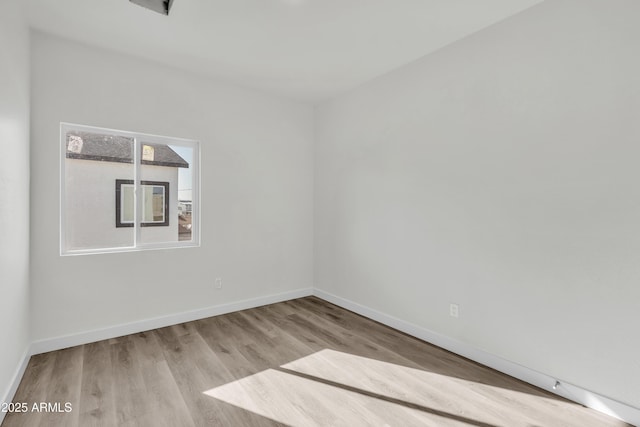 empty room featuring wood finished floors and baseboards