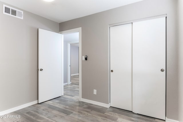 unfurnished bedroom featuring light hardwood / wood-style floors and a closet