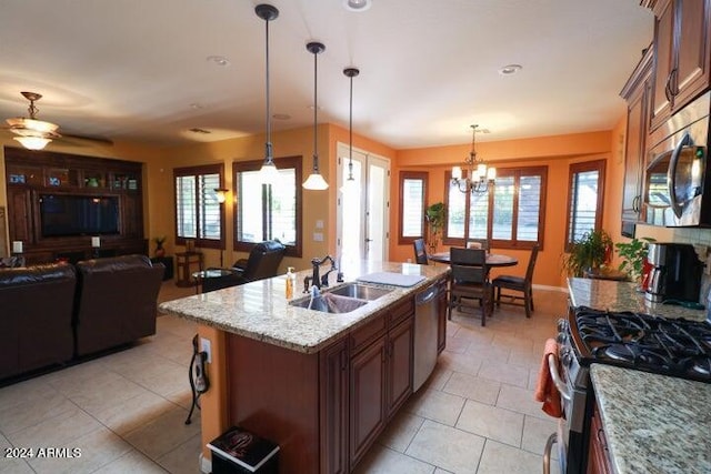 kitchen featuring sink, plenty of natural light, light tile floors, and pendant lighting