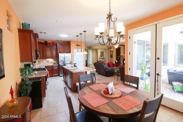 dining area featuring a chandelier, light tile floors, and a wealth of natural light