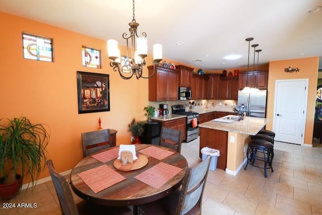 tiled dining area featuring an inviting chandelier and sink