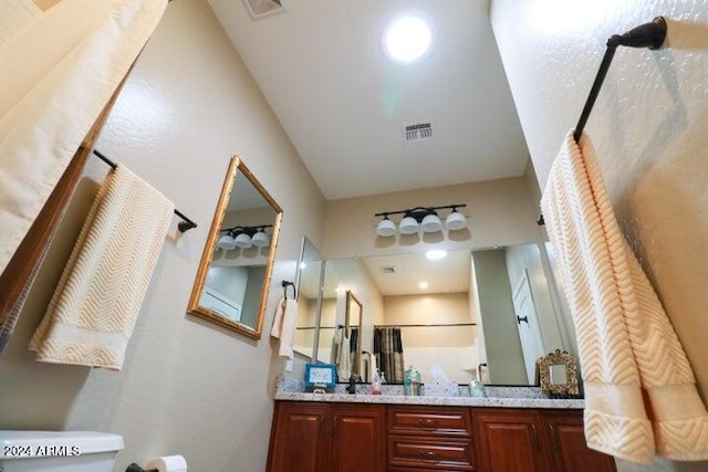 bathroom featuring dual sinks, toilet, and large vanity