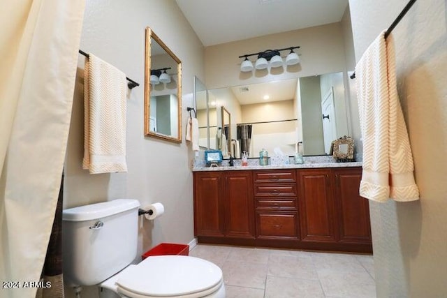 bathroom featuring toilet, tile floors, and double vanity